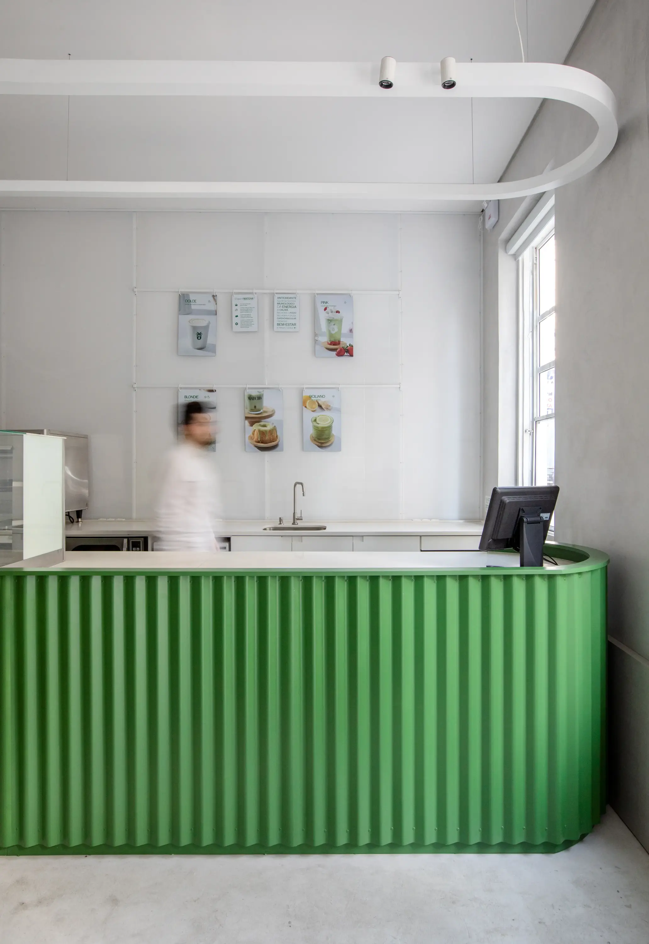 Balcão verde vibrante com iluminação suave no projeto Green Blood, assinado pelo Studio Guilherme Garcia