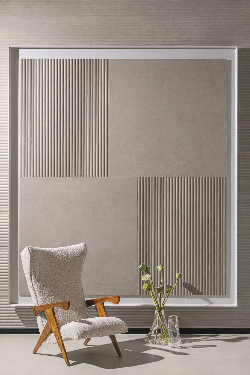 Revestimentos verticais em tons neutros com cadeira e vaso de planta ao lado no espaço Portobello Revestir 2025 – Studio Guilherme Garcia